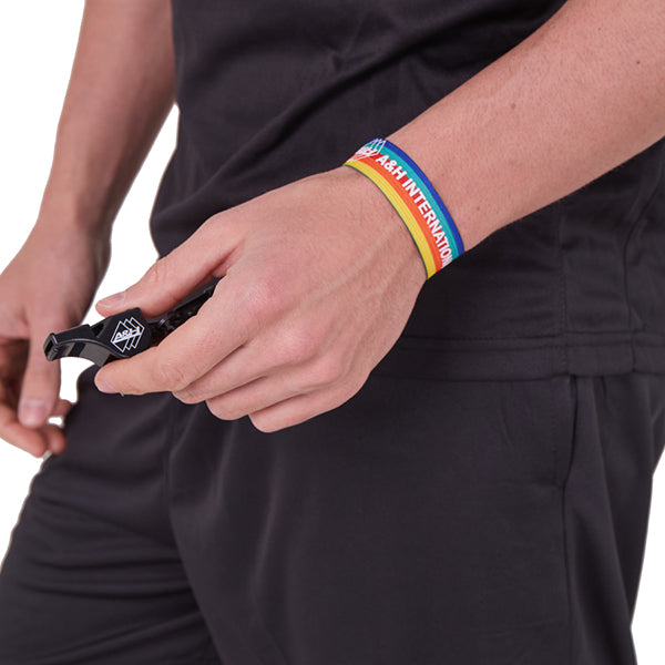 Referee wearing the A&H rainbow wrist lanyard with a whistle attached