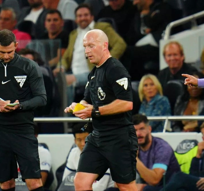 Referee in a stadium using a yellow match wallet during a match