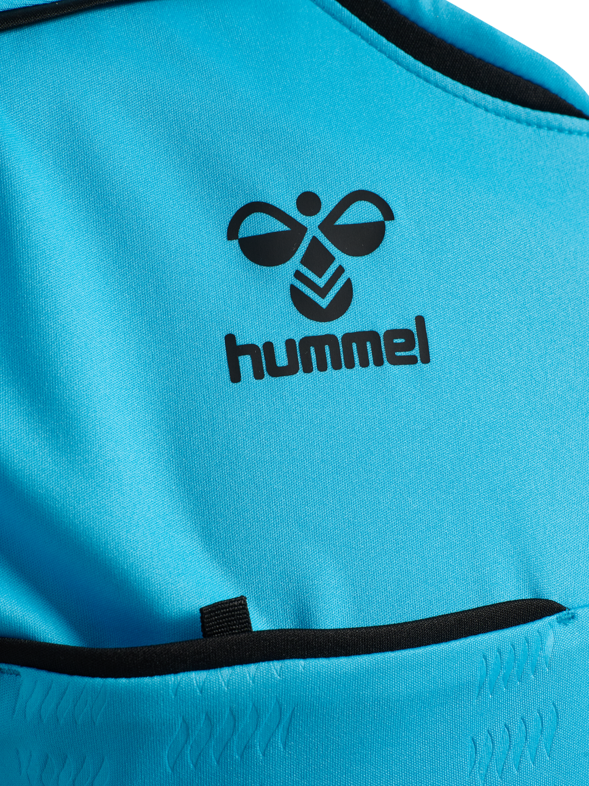 Close-up of the Hummel logo and chest pocket on the blue Hummel 2026 referee shirt