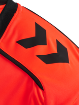 Close-up of the Hummel chevron sleeve detail on the orange Hummel 2026 referee shirt