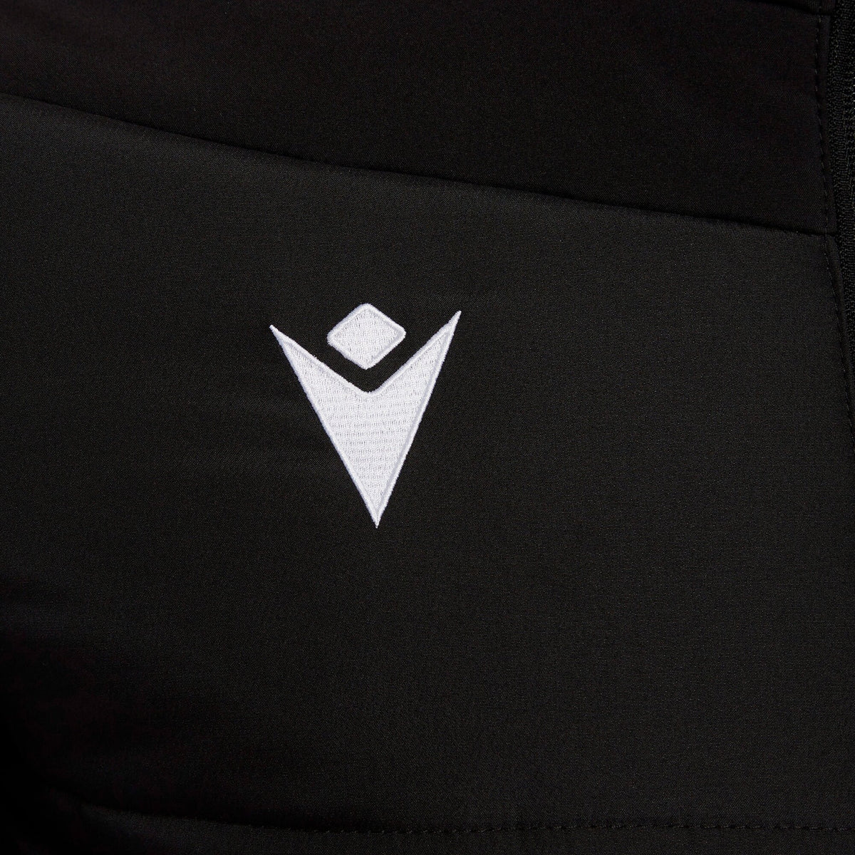 Close-up of the Macron logo on the black Macron referee winter jacket