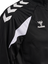 Close-up of the Hummel logo and chevron sleeve on the black Hummel referee full-zip jacket