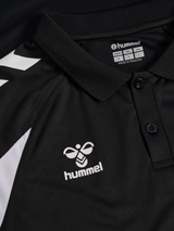 Close-up of the Hummel logo and collar on the black Hummel referee polo shirt