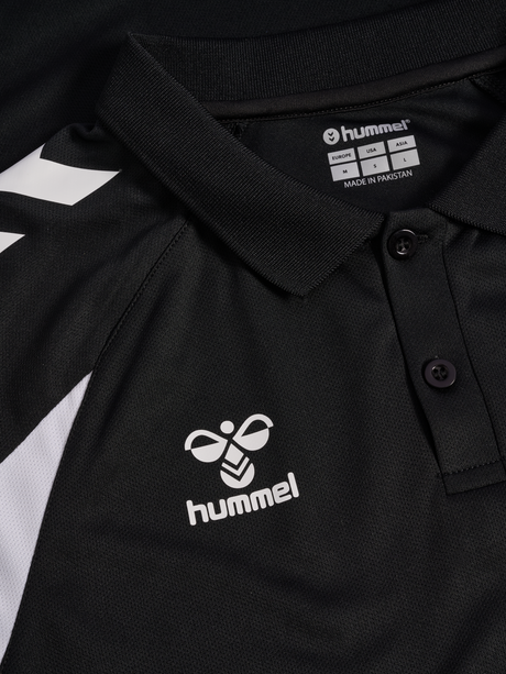 Close-up of the Hummel logo and collar on the black Hummel referee polo shirt