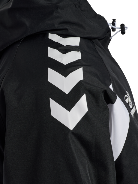Close-up of the white chevrons on the sleeve of the black Hummel referee rain jacket