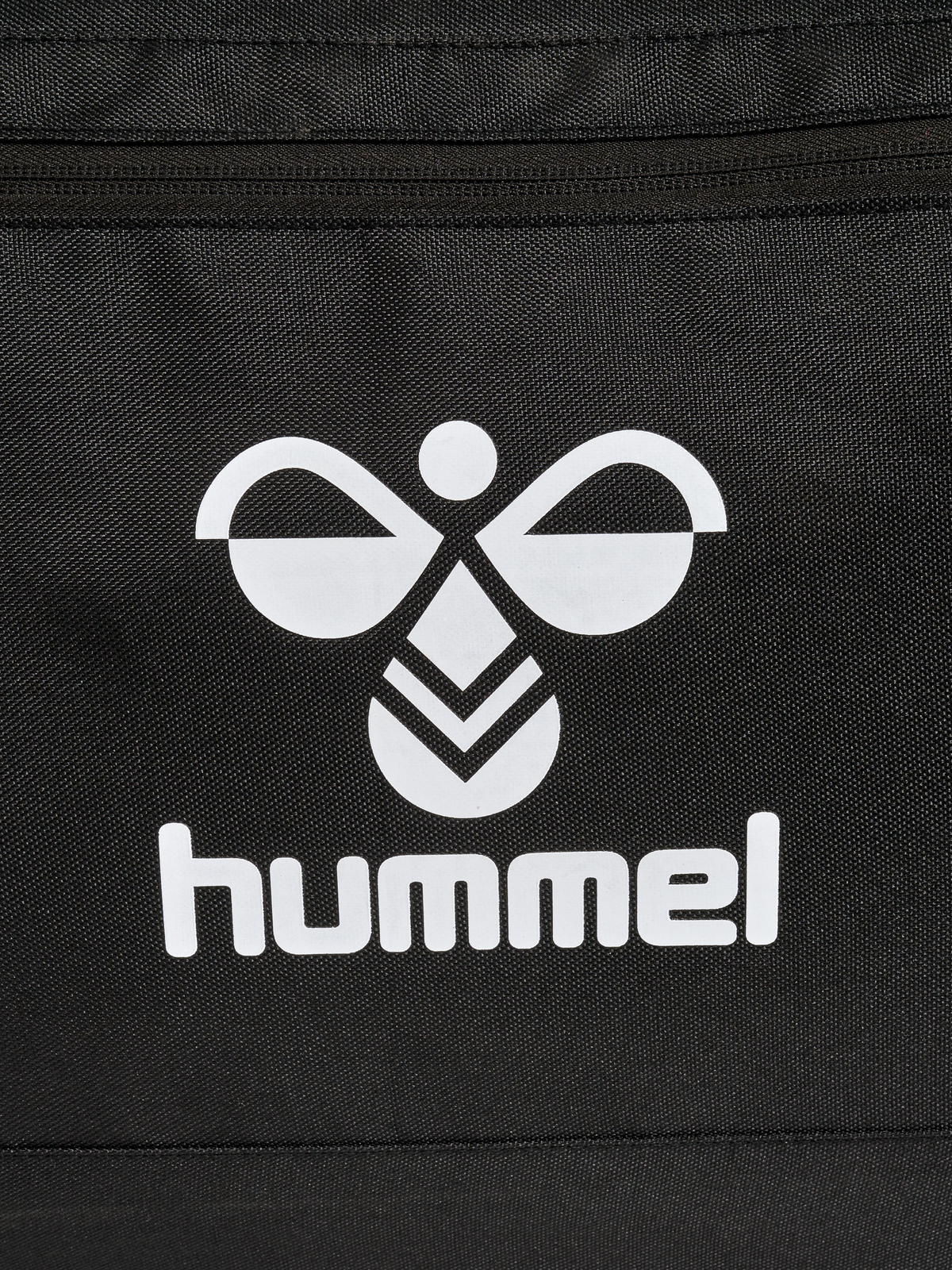 Close-up of the white Hummel logo on the black Hummel roller bag