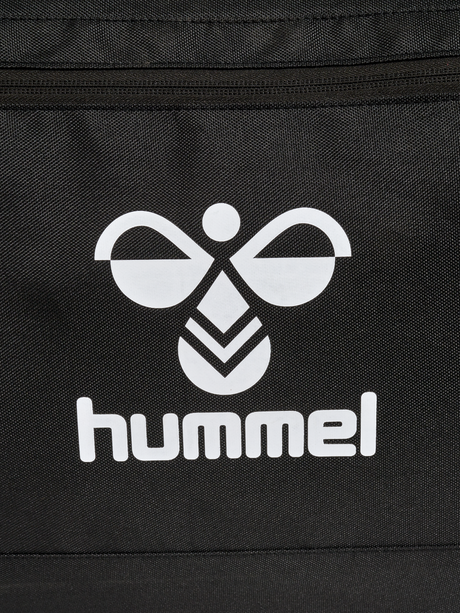 Close-up of the white Hummel logo on the black Hummel roller bag
