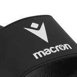 Close-up of the white Macron logo on the black Macron slide