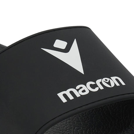 Close-up of the white Macron logo on the black Macron slide