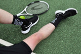 Player sitting on a pitch wearing Precision grip socks with trainers