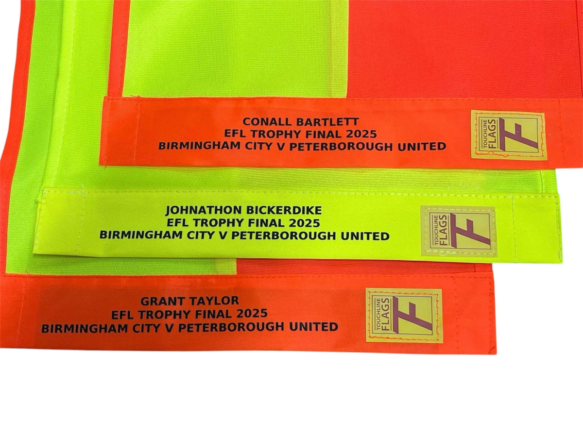 Touchline Premier League flag cloths stacked, showing embroidered match details